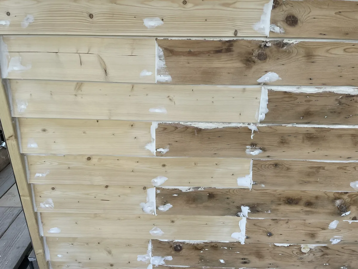 Weatherboards stripped back to bare timber with defects filled by hand during preparation on a cottage in Cranbrook