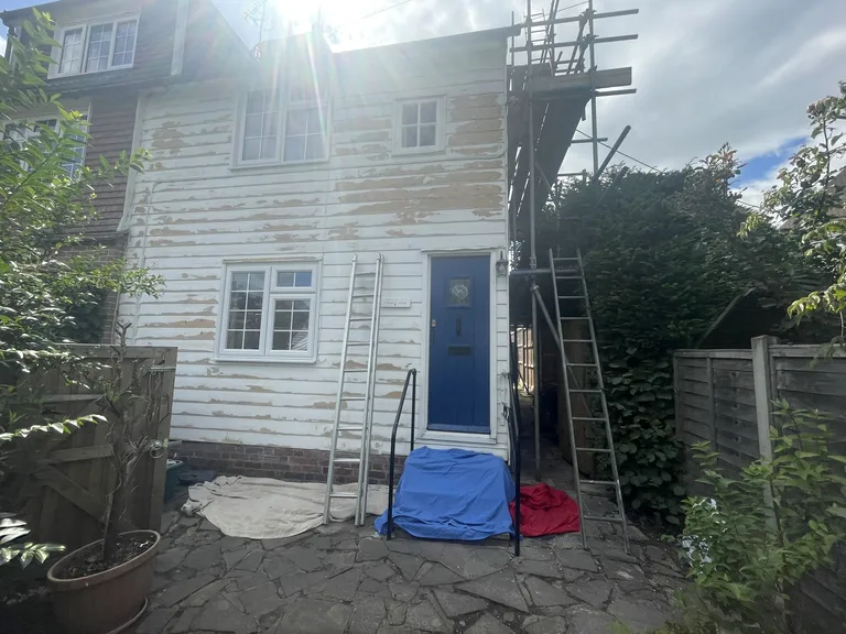 Badly flaking white paint on the weatherboards of Angela Cottage in Cranbrook before restoration