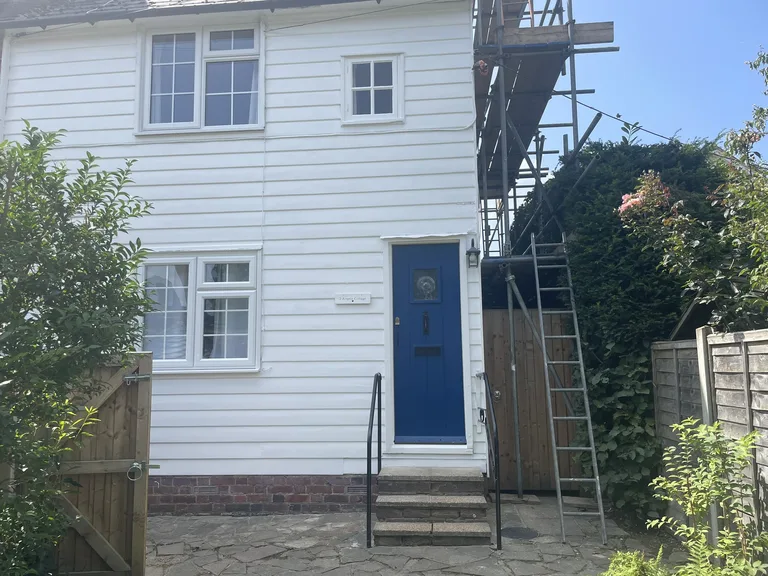 Angela Cottage in Cranbrook with a crisp white weatherboard finish and smart blue front door after full restoration