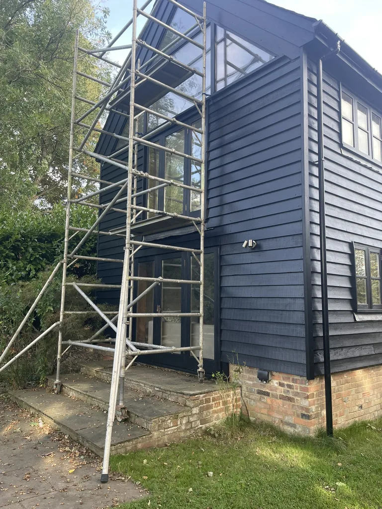 Scaffold erected on the gable end of a Hawkhurst barn conversion during dark-finish repainting
