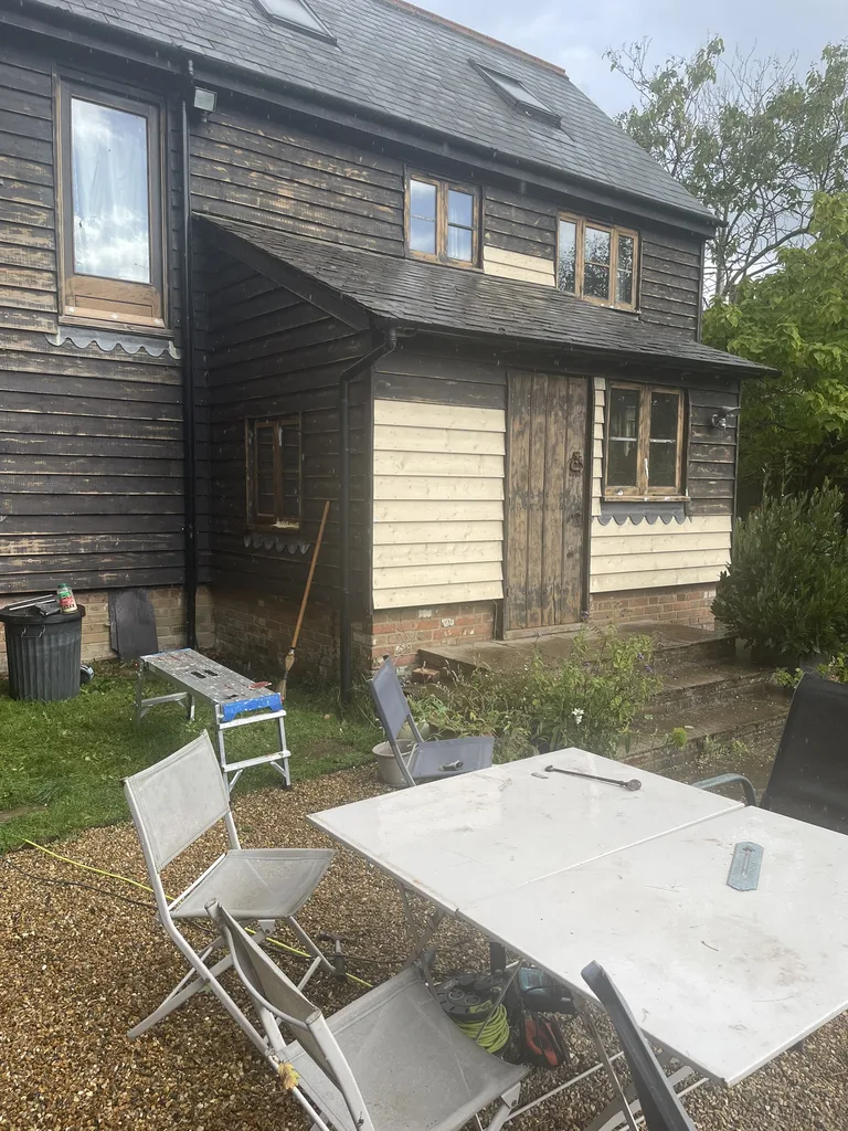 Side elevation of a Hawkhurst barn conversion being repainted in a dark satin finish