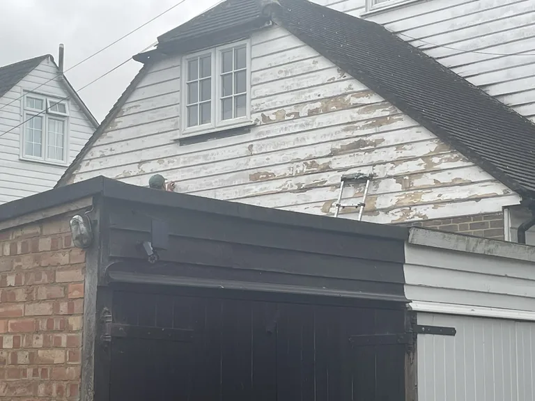 Flaking weatherboard paintwork on a cottage in Cranbrook, Kent, before repainting