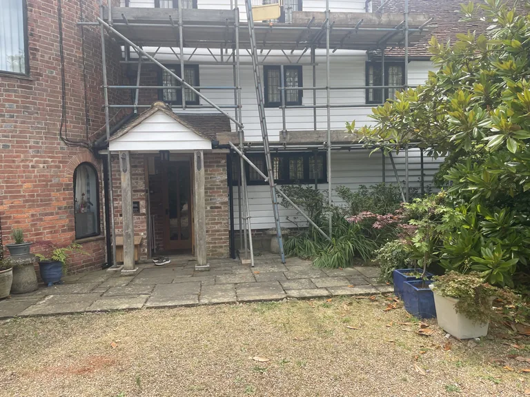 Front elevation of the Grade II listed oast house near Rye under independent scaffolding during weatherboard restoration