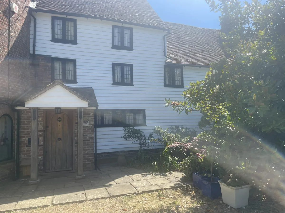 The completed and repainted front porch elevation of a Grade II listed oast house in Northiam, East Sussex, after weatherboard restoration