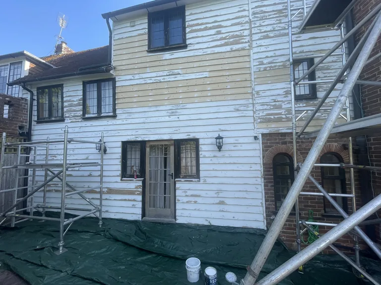 Weatherboard repair and replacement in progress on the rear of a listed oast house near Rye