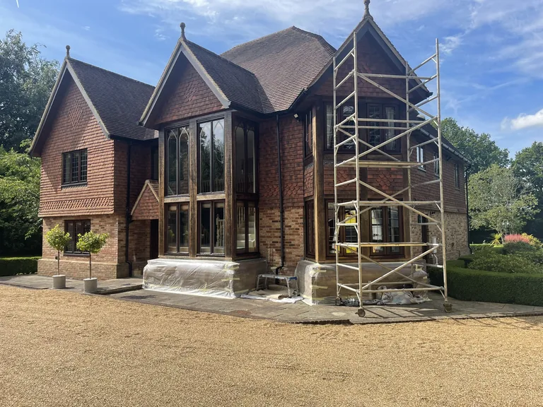 Careful masking of the brick plinth around oak window frames in Hawkhurst — attention to detail