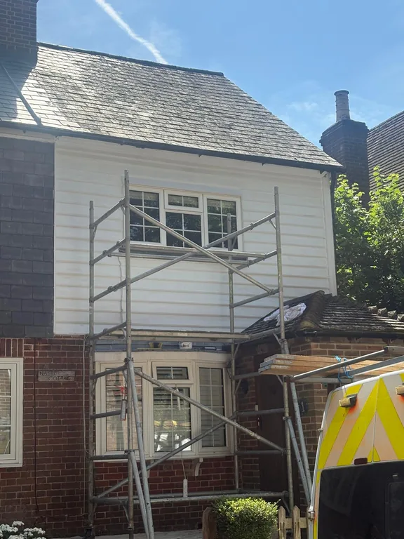 Independent scaffolding erected around a Fletching cottage with freshly painted white weatherboards during restoration