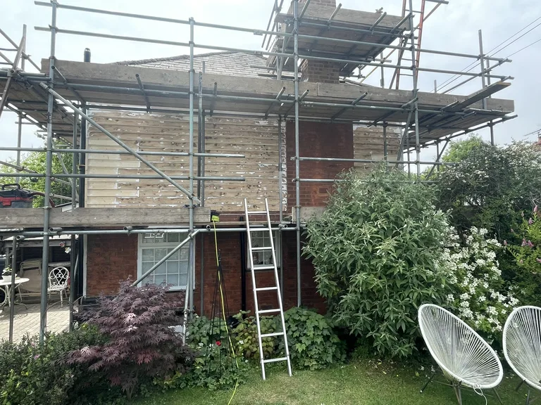 Stripped and weathered weatherboards on the upper storey of a house in Ticehurst, East Sussex, before restoration