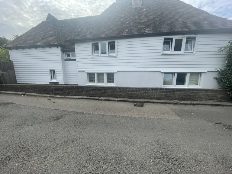 Finished white weatherboarding on the front elevation of a cottage in Boughton Monchelsea, Kent