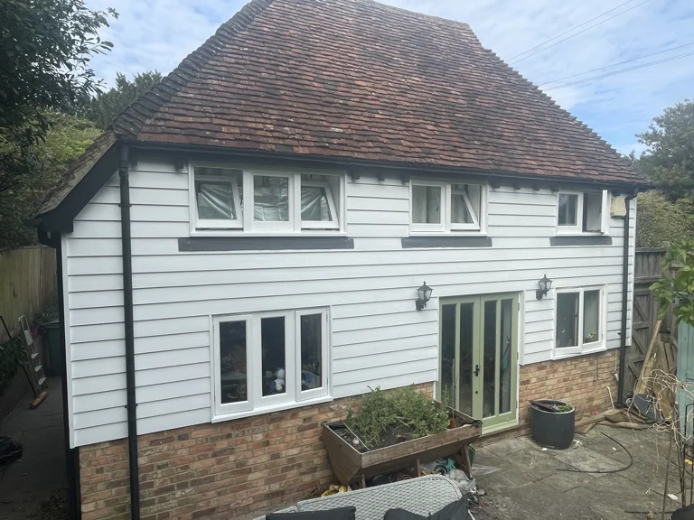 Finished white weatherboarding and painted frames on the rear elevation in Boughton Monchelsea